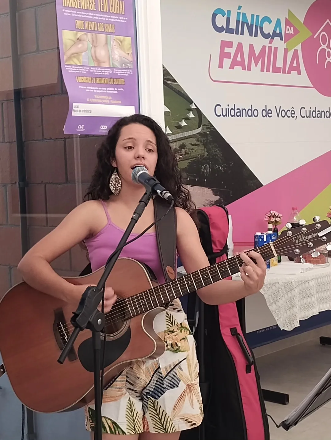 Victoria cantando e tocando violão ao ar livre